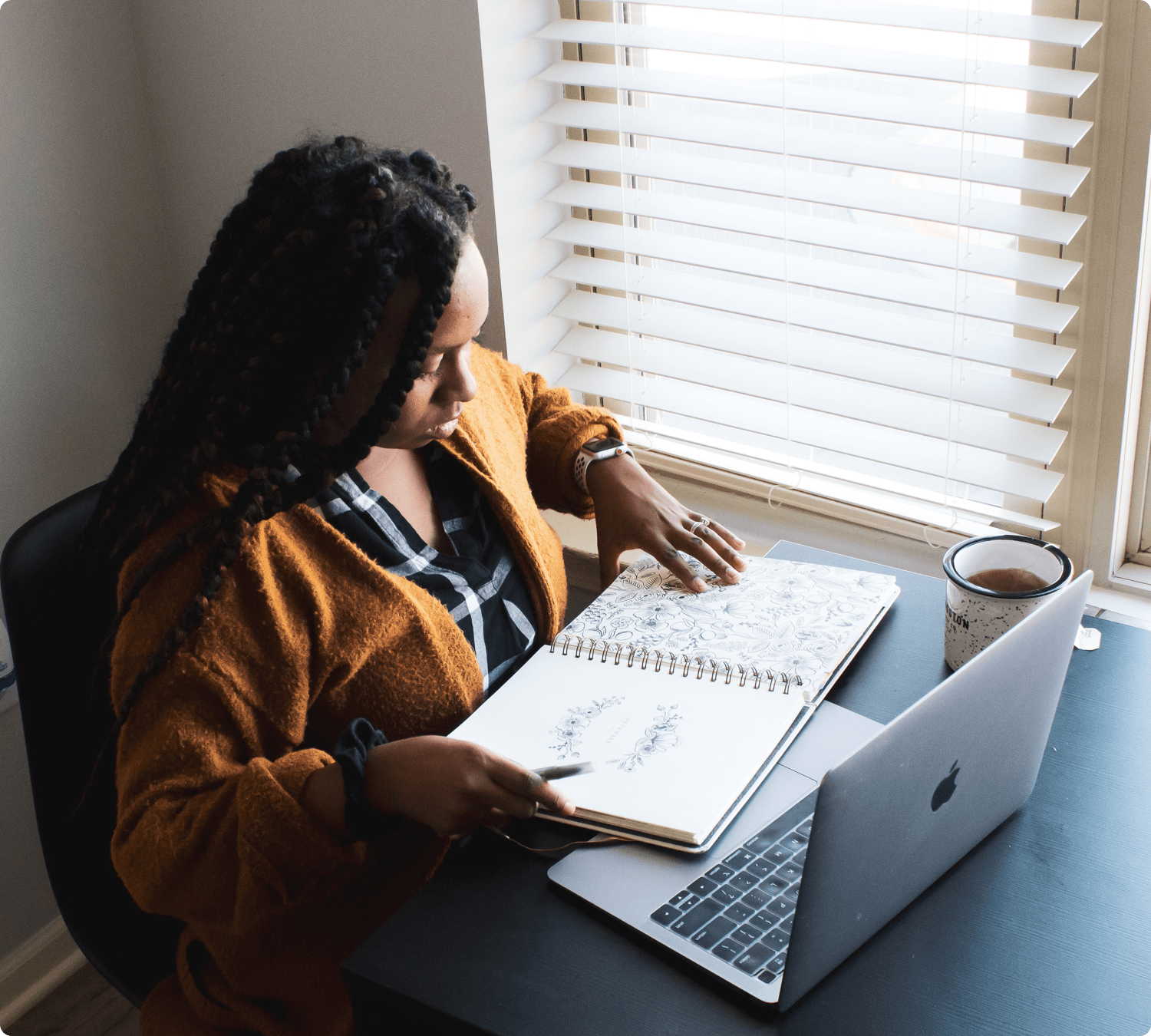 Woman working at computer with notebook